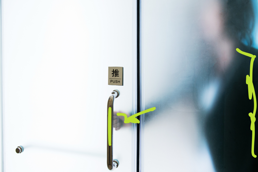 Frosted glass door with a handle and a PUSH sign, behind it the blurred silhouette of a person